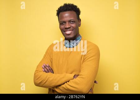 Young handsome african business man posing isolated over yellow wall Stock Photo