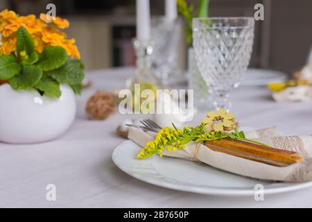 Easter festive spring table setting decoration, eggs in nest, feathers, family dinner or breakfast concept Stock Photo
