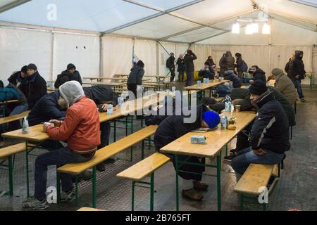 Refugees warm themselves in a heated waiting tent at the State Office for Health and Social Affairs, LaGeSo, in Berlin. [automated translation] Stock Photo