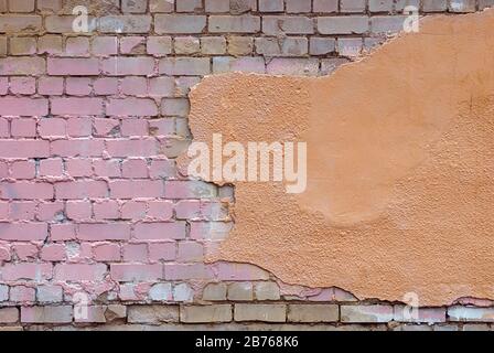 old damaged brick wall with stucco and paint stains Stock Photo