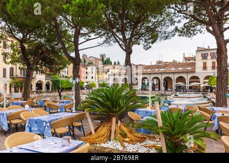 August 12 2019 - Desenzano del Garda, Brescia, Lombardy, Italy - Empty seats and tables at a restaurant terrace Stock Photo