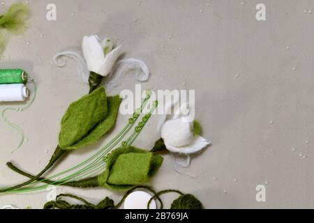 Corner snowdrops made of wool made by hand and material with tools. Stock Photo