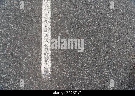 Asphalt road texture,  Grainy background,small chopped stones black and gray with a white guide line road Stock Photo