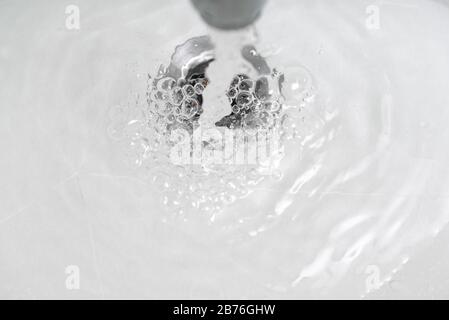 water flow in facuet making bubbles from above Stock Photo