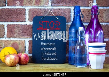 Cafe sign, stop wash hands then help yourself to water and vitamin C, community coronavirus covid19 spreading prevention Stock Photo