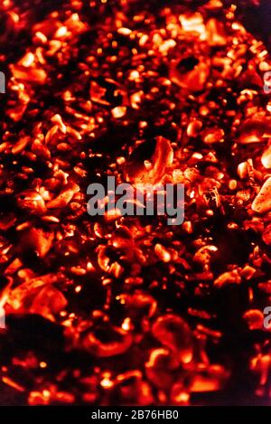 Close-up of red embers in the night with shallow depth of field Stock Photo