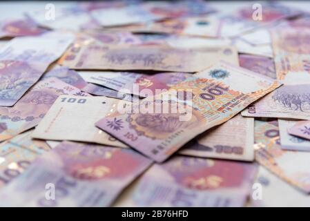 Argentinian one hundred pesos bill money scattered on a table Stock Photo