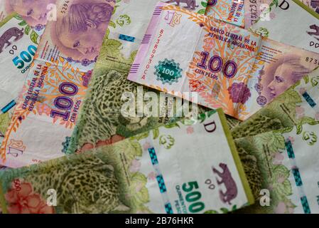 Argentinian one hundred pesos and five hundred pesos bill money scattered on a table Stock Photo