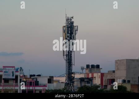 Jaipur, India, Circa 2020 - Photograph of a telephone tower situated in the middle of a residential area. The tower is made of metal and is used to bo Stock Photo