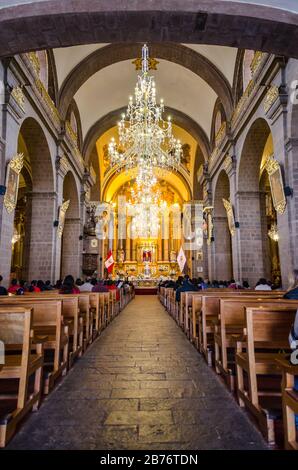 Inside of La Merced Convent with chandeliers, pulpit and altar in Cusco, Peru Stock Photo