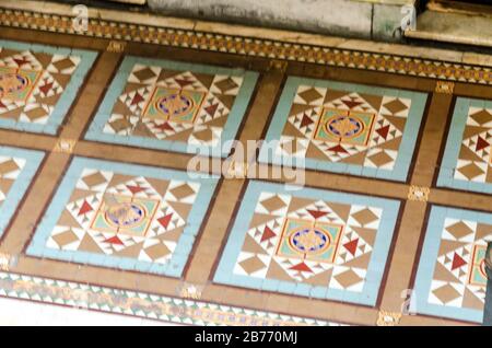 Old ceramic floor detail with colors brown, light blue, gold, red and white with perspective Stock Photo