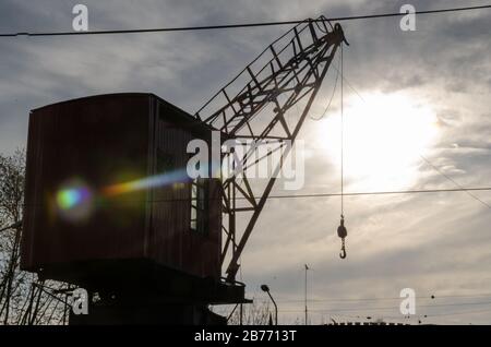 silhouette of river crane against the sun on a cloudy day Stock Photo