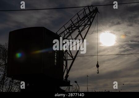 silhouette of river crane against the sun on a cloudy day Stock Photo