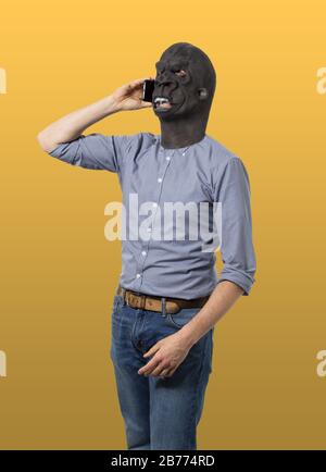 Vertical shot of a male in a black angry mask talking on a phone Stock Photo