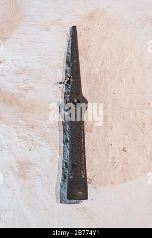 Pickaxe hanging on a white wall Stock Photo
