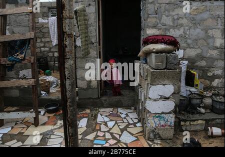 Gaza, Palestine. 13th Mar, 2020. A child stands at her house door during a cold weather wave in the outskirts of the poor neighbourhood of Khan Yunis refugee camp. Credit: SOPA Images Limited/Alamy Live News Stock Photo