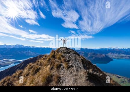 Young Asian couple celebrating success at Roy's Peak Lake Wanaka New Zealand Stock Photo