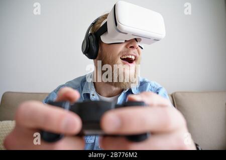 Young man in vr headset play video game virtual reality concept copy space. Stock Photo