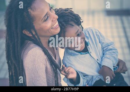 Family happy and playful time together - mother and son black african race people have fun at the park - love for mother and young son - dreadlocks ha Stock Photo