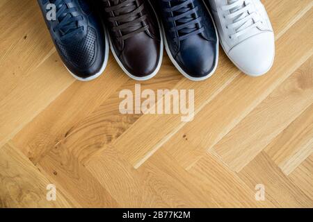 stylish men's shoes. men fashion still life. different boots, sneakers, on wooden background Stock Photo