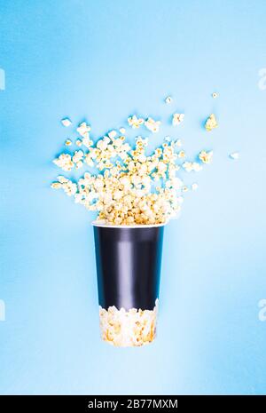 Scattered popcorn on a blue background. Abstraction and minimalism. Stock Photo