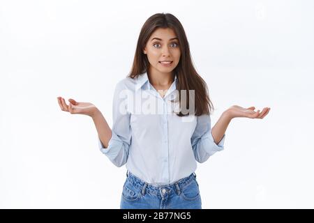 Sorry for making mistake didnt know. Clumsy cute assistant apologizing for forgetting something, shrug with hands spread sideways and embarrassed Stock Photo