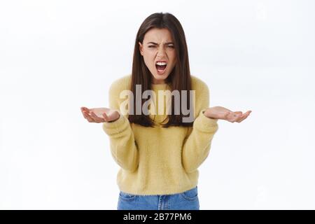 Whats wrong with you. Woman having argument screaming at person with angry outraged and frustrated expression, raise hands in dismay cursing in rage Stock Photo