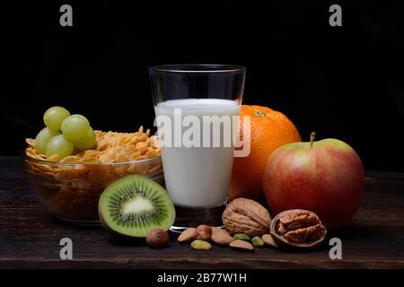 A glass of milk, bowl with cornflakes, fruits and nuts, Germany Stock Photo