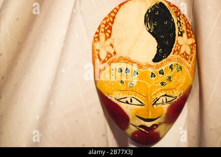 Traditional Dance Acessory: Yellow Indonesian Wayang Mask on a white curtain Stock Photo
