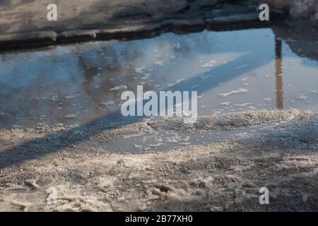 Spring puddles, snowdrifts, snow, mud and melted dirty water Stock Photo