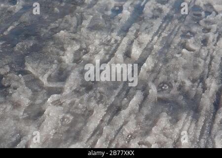 Spring puddles, snowdrifts, snow, mud and melted dirty water Stock Photo