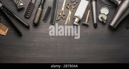 Classic grooming and hairdressing tools on wooden background. Top view on barbershop instruments  laying on dark wooden table. Stock Photo