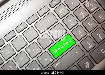 Green button on the computer with the text Healed Stock Photo