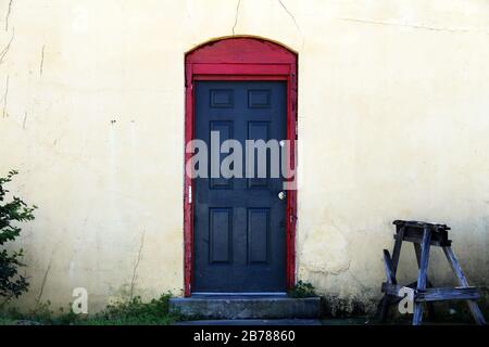 a black door with red trim at a vintage workshop entrance Stock Photo