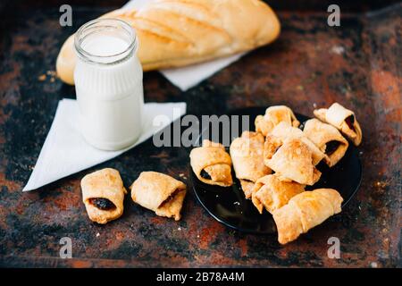 Nice breakfast - milk with croissants on black rustic surface Stock Photo