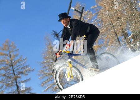 Schornsteinfeger auf dem Mountainbike im Schnee Stock Photo