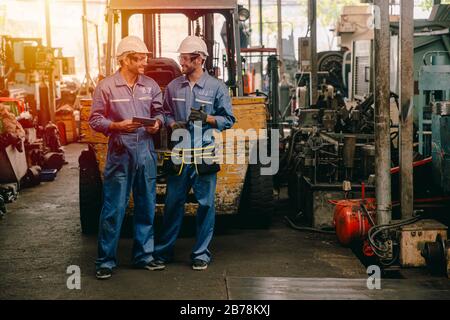 happy worker, working in heavy industry talking smiling together. Stock Photo