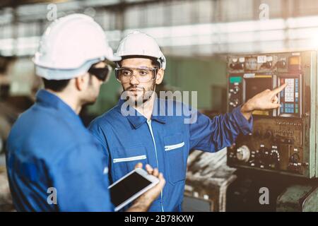 Engineer team talking together to discussion teach and learn give education technical about using machine in factory workplace. Stock Photo