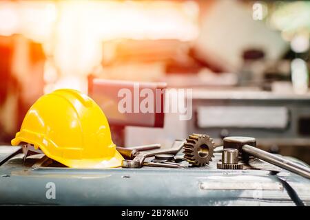 yellow helmet hardhat with instruments gear tools in factory for background. Stock Photo