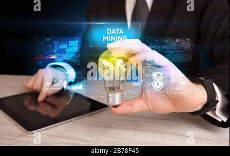 Businessman holding lightbulb with DATA MINING inscription, online security idea concept Stock Photo