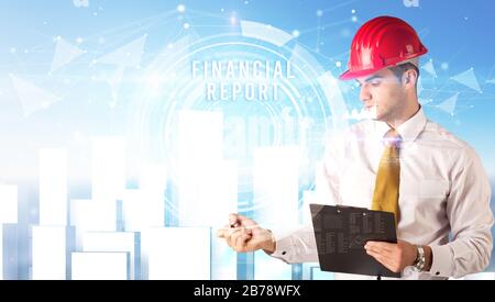 Handsome businessman with helmet drawing FINANCIAL REPORT inscription, contruction business concept Stock Photo