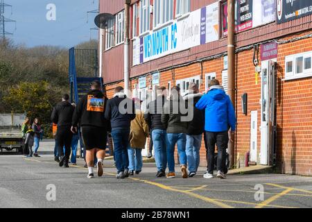 Weymouth, Dorset, UK.  14th March 2020.  Fans arriving for the Weymouth FC v Slough Town Vanarama National League South match at the Bob Lucas Stadium ahead of the 3pm kickoff.  Most National league football is still playing this weekend despite the Premier League and EFL shutting down due to the coronavirus.  Picture Credit: Graham Hunt/Alamy Live News Stock Photo