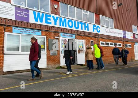 Weymouth, Dorset, UK.  14th March 2020.  Fans arriving for the Weymouth FC v Slough Town Vanarama National League South match at the Bob Lucas Stadium ahead of the 3pm kickoff.  Most National league football is still playing this weekend despite the Premier League and EFL shutting down due to the coronavirus.  Picture Credit: Graham Hunt/Alamy Live News Stock Photo