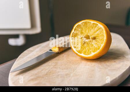 Half lemon and knife on a cutting board Stock Photo