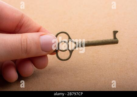 Hand holding a retro styled decorative key in hand Stock Photo