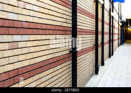 Red and beige painted brick wall background texture close up. View in depth. Selective focus. Stock Photo