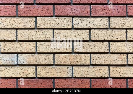 Red and beige painted brick wall background texture close up. Stock Photo