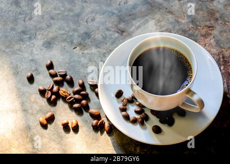 coffee cup coffee beans on the cement  background with a smoky aroma Stock Photo