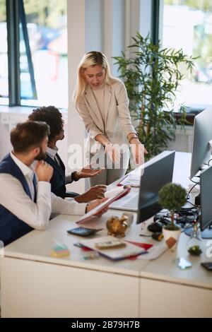 Angry team manager woman with young employees working together. Stock Photo