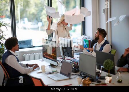 young angry leader woman yelling on young employees. Stock Photo